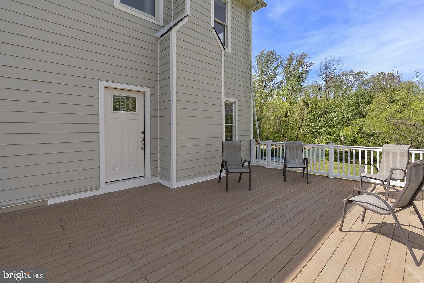 The side deck off the kitchen, looking out over the wooded grounds bordered by the Land Conservancy