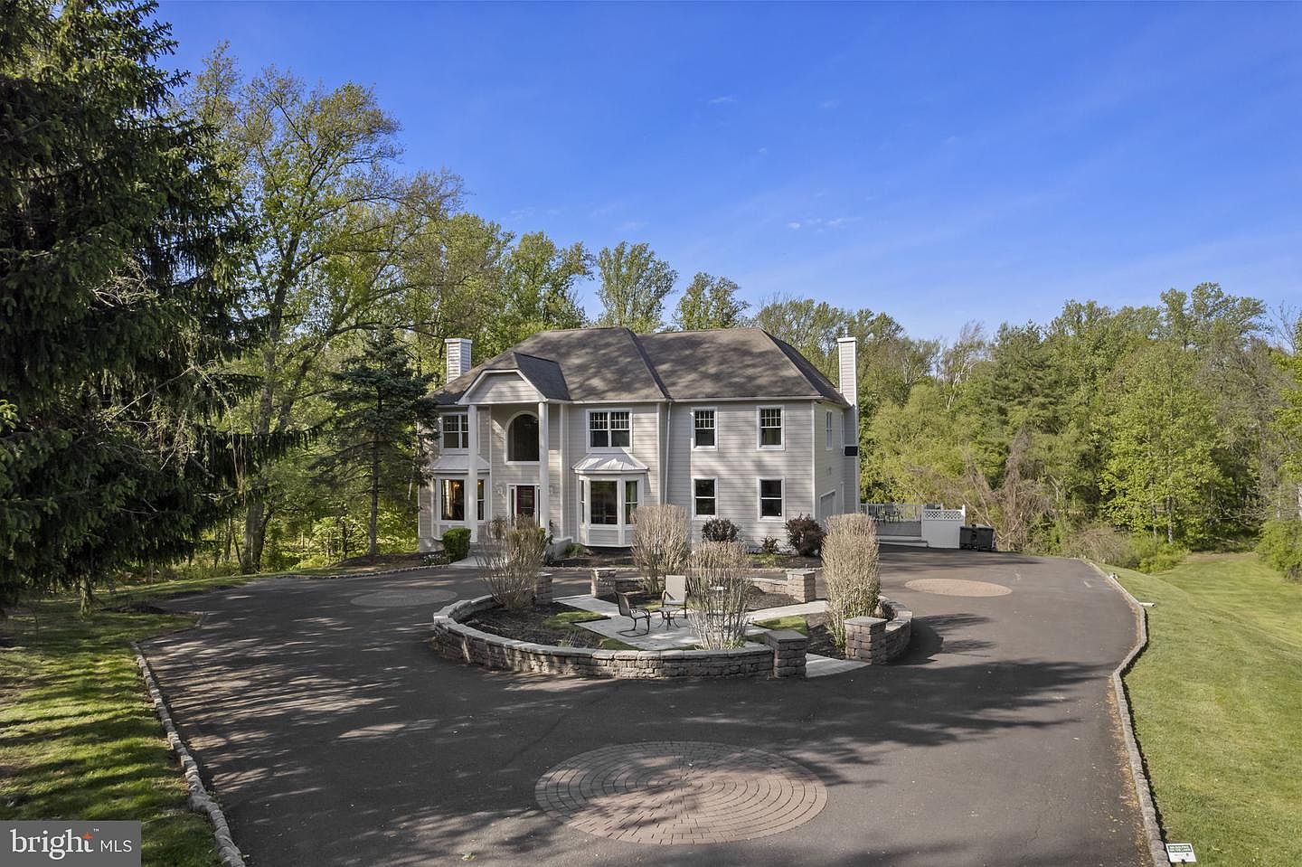 Custom Colonial residence at 2321 Old Bristol Road, set against mature trees with a circular stone-rimmed front patio and curving driveway